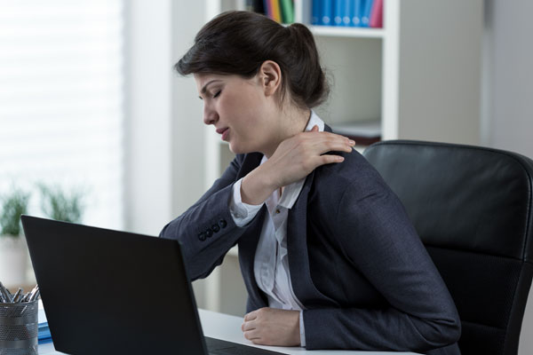 woman at the computer with shoulder and rotator cuff pain